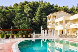 Una piscina al aire libre de temporada, sombrillas