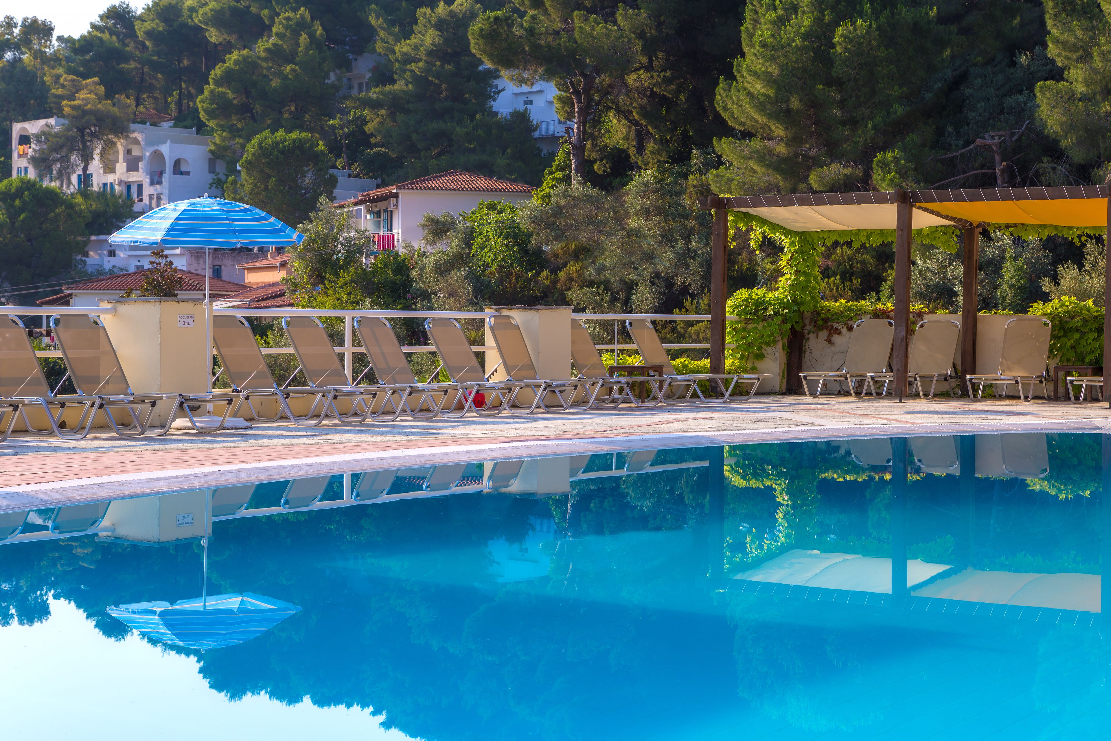 حمّام سباحة خارجي موسمي، مظلات على حمّام السباحة، مقاعد للتشمس