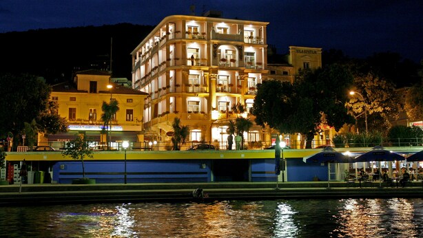 Ein mehrstöckiges Hotel mit Balkonen und Blick auf das Wasser.