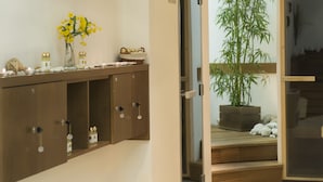 Ein Korridor mit einem Holzschrank, einer Topfpflanze und einer Tür zu einem anderen Raum.