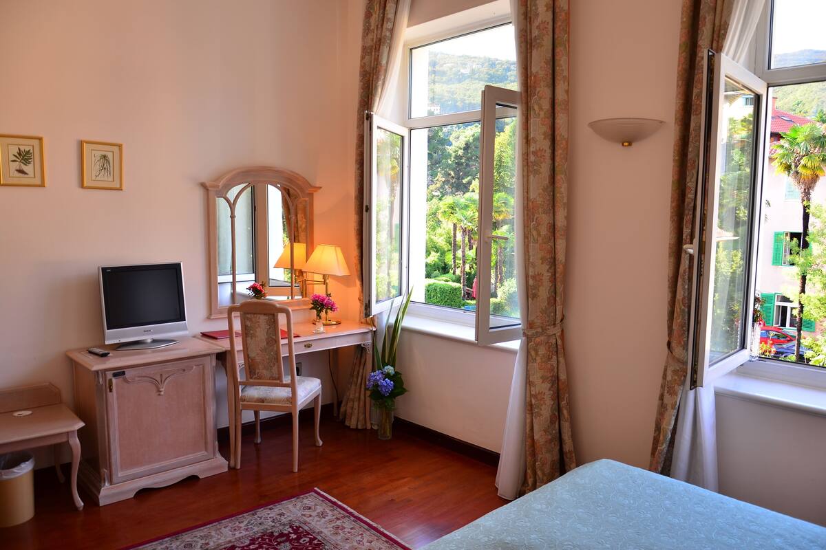 Un dormitorio con escritorio, silla y cama.