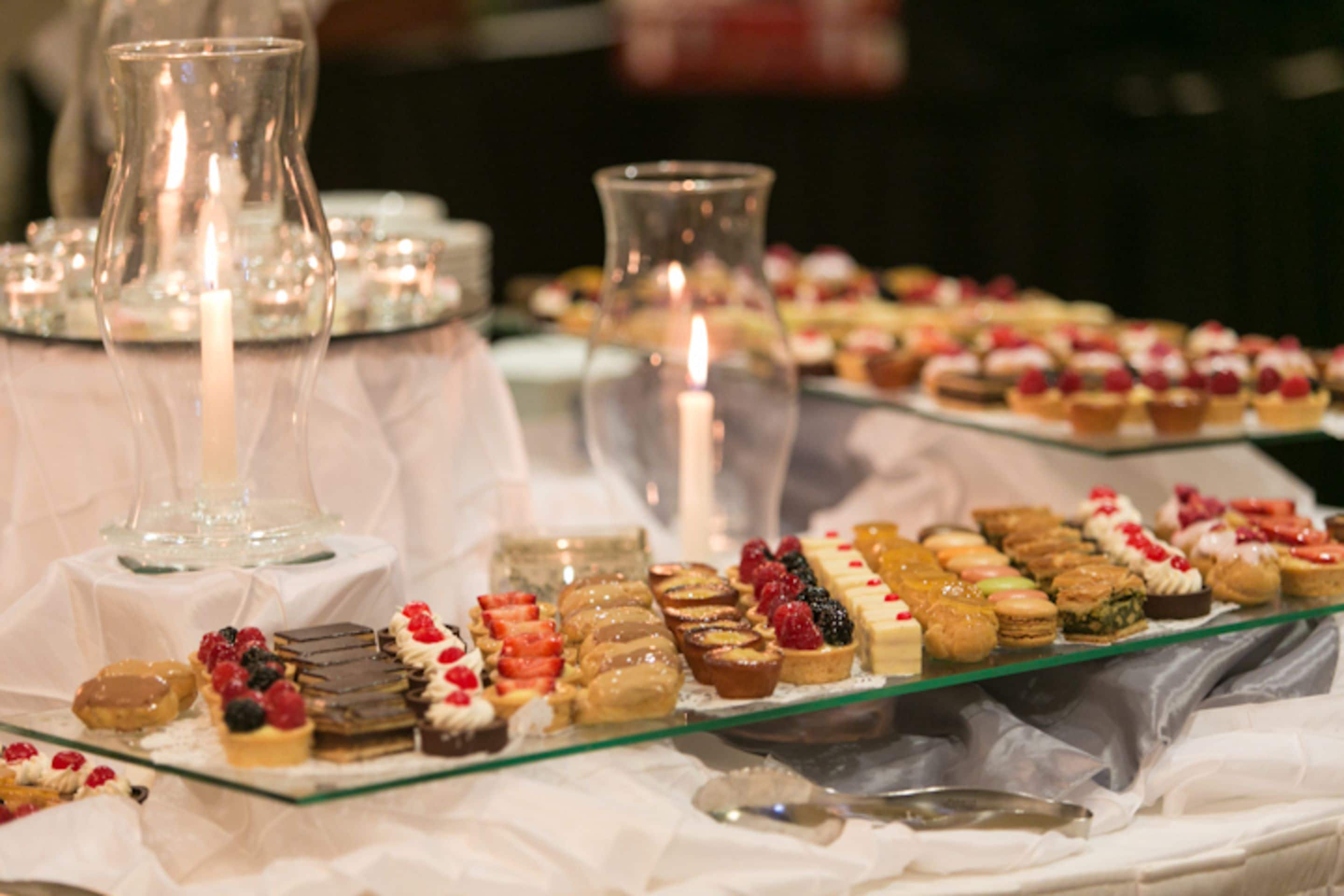 A buffet table with various desserts and a candle.