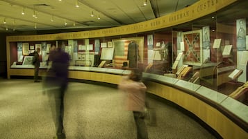 A museum exhibit with glass display cases containing historical artifacts and documents.