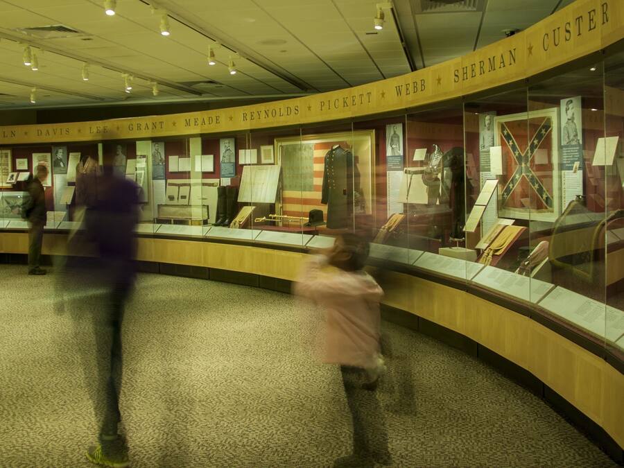 A museum exhibit with glass display cases containing historical artifacts and documents.
