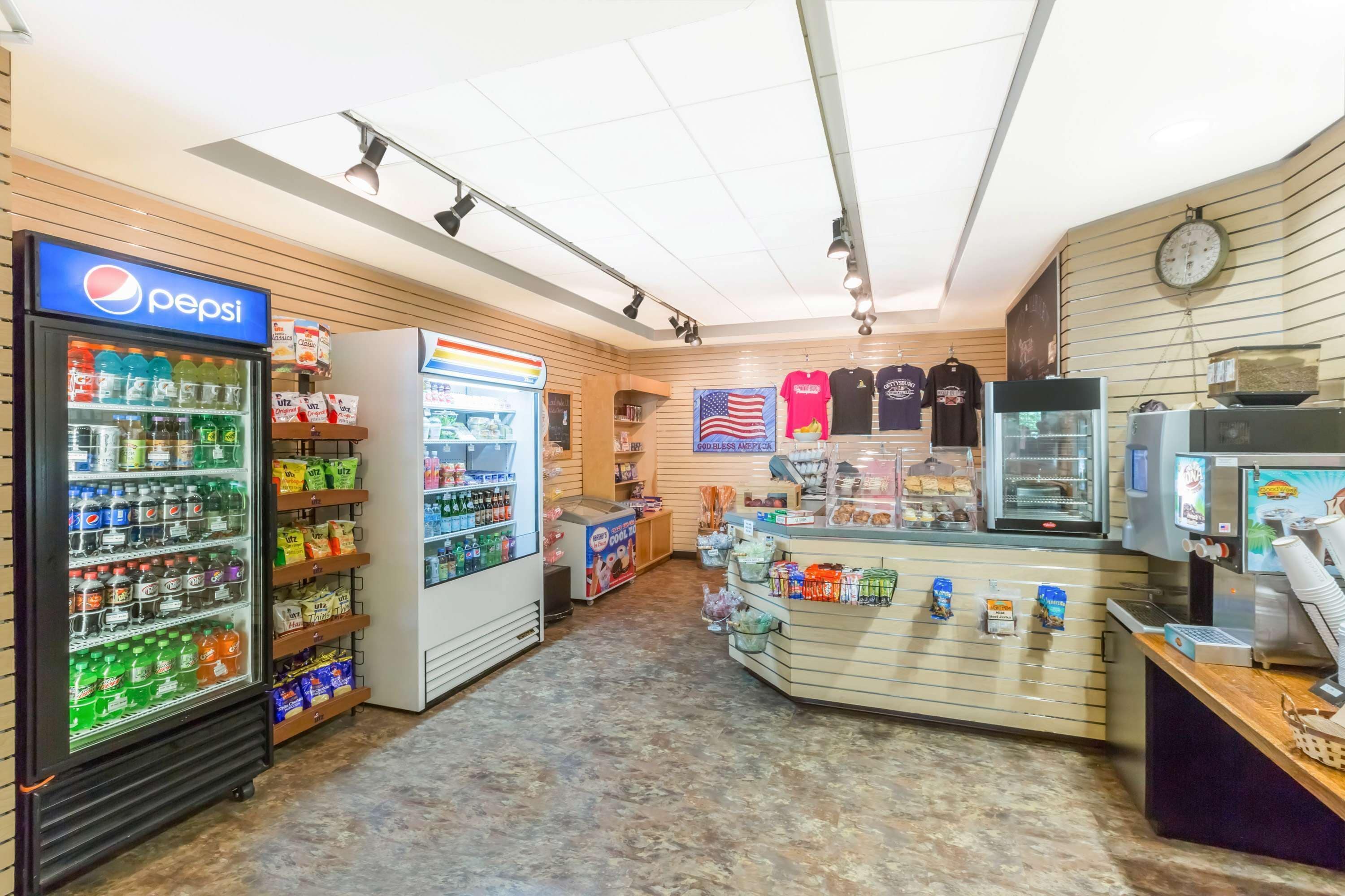 A convenience store with a Pepsi refrigerator, a refrigerated display, and a variety of snacks and beverages.