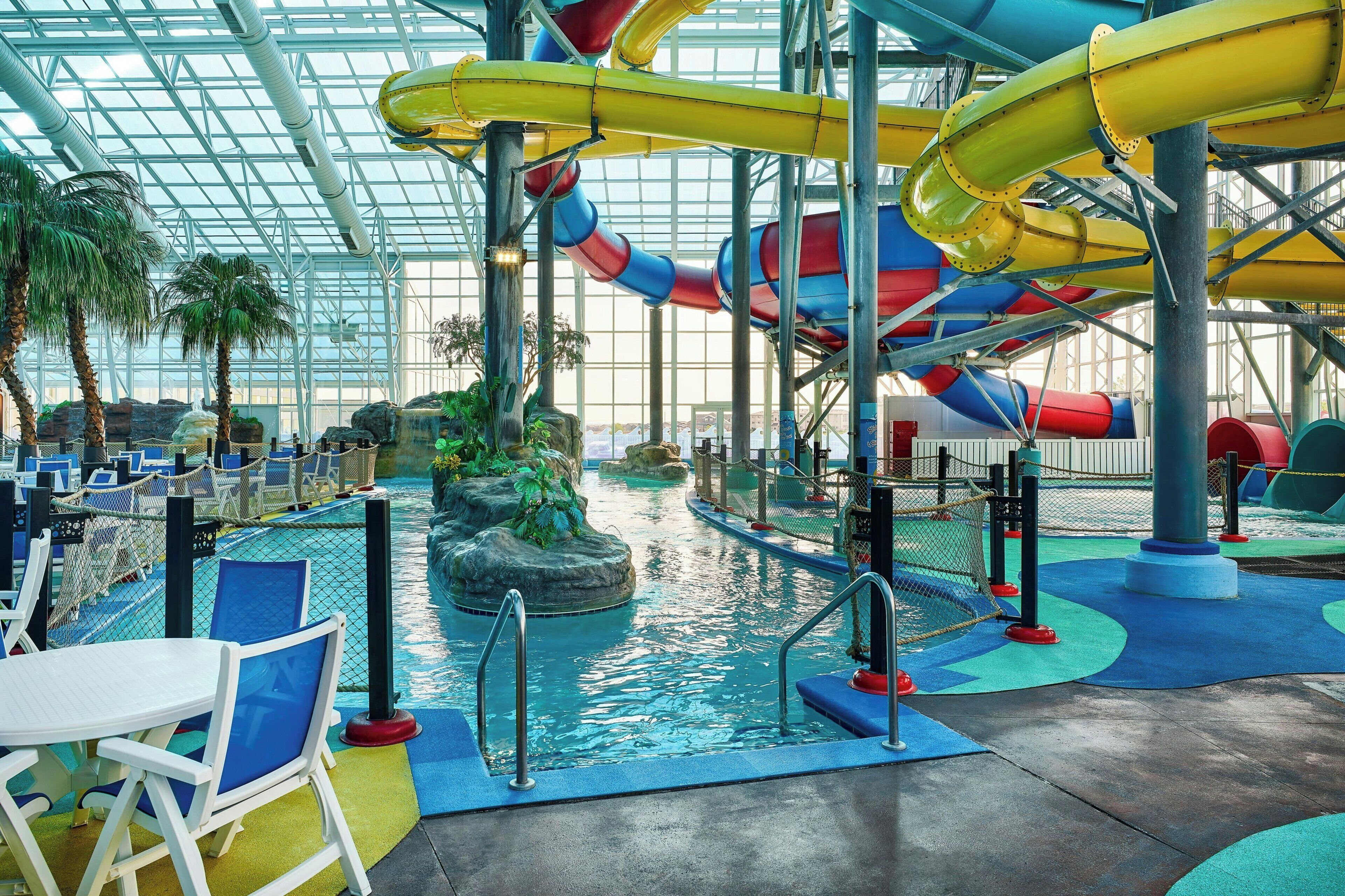 Parque acuático interior con toboganes y piscinas.