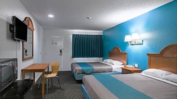 A hotel room with two beds, a desk, a chair, a TV, and a microwave.