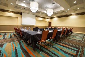 A conference room with a large table, chairs, a projector screen, and a carpeted floor. - Drury Inn & Suites Columbus Grove City (Grove City)
