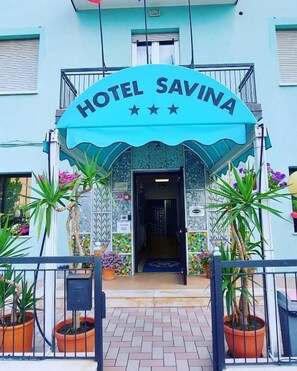 A hotel entrance with a sign reading 'HOTEL SAVINA' and a tiled facade. - Hotel Savina (Rimini)