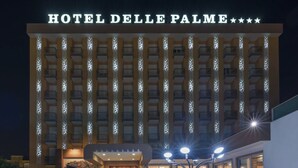A hotel with a prominent sign reading "HOTEL DELLE PALME" and a series of balconies with lights. - Hotel Delle Palme (Lecce)