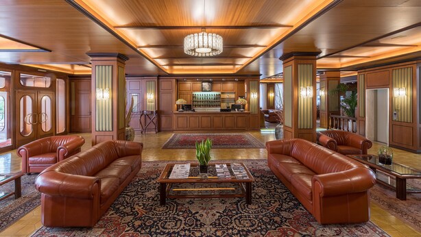 A spacious lobby with leather sofas, a central coffee table, and a reception desk. - Hotel Delle Palme (Lecce)