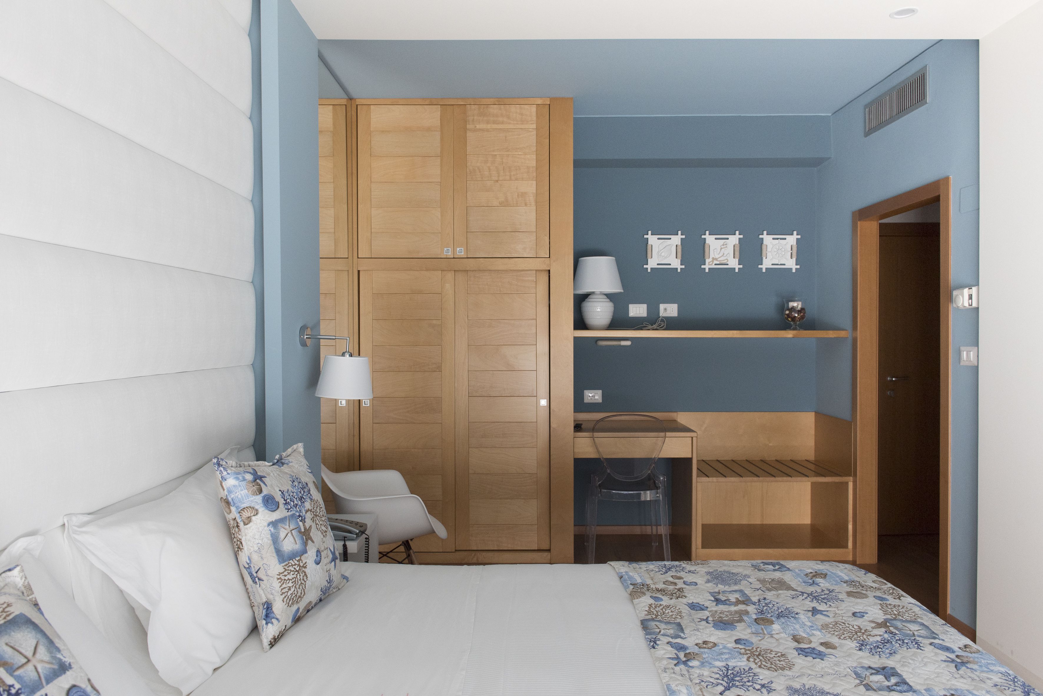 Quarto com cama, escrivaninha, cadeira e guarda-roupa.