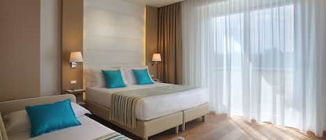 Habitación triple Deluxe, 1 habitación, balcón | 1 dormitorio, minibar, caja fuerte y escritorio