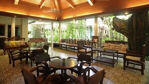 An indoor seating area with wooden furniture and a patterned floor. - Sino House Phuket Hotel (Phuket)
