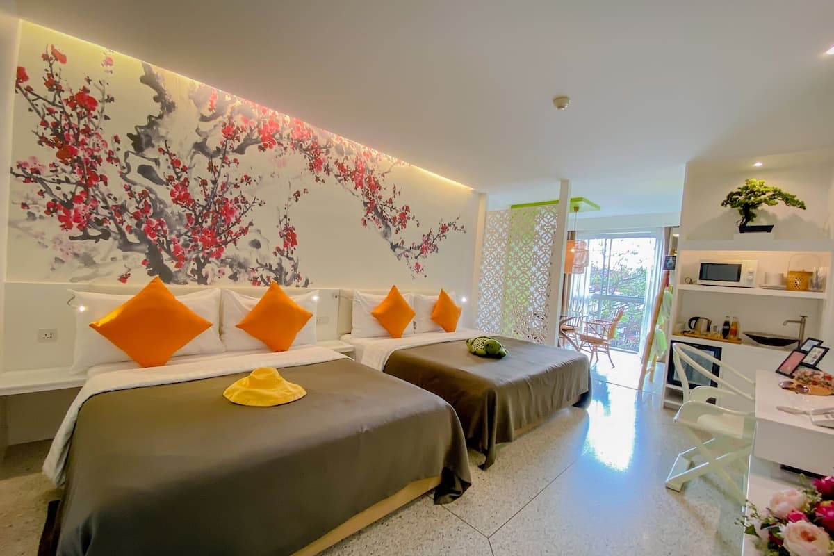 Une chambre d’hôtel avec deux lits, un bureau et une grande fenêtre.