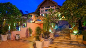 A hotel entrance with a staircase leading up to the main building, surrounded by potted plants and outdoor lighting. - Seaview Patong Hotel (Patong)
