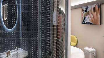 Relax in a stylish room with a large mirror, modern sink, and glass shower enclosure.