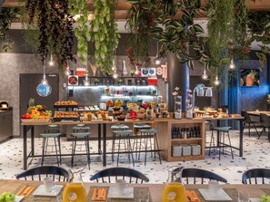 A modern cafe with a central bar area, multiple seating options, and a variety of food and drink displays.