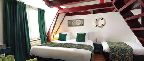 A bedroom with two beds, a green chair, a painting, and a welcome sign.