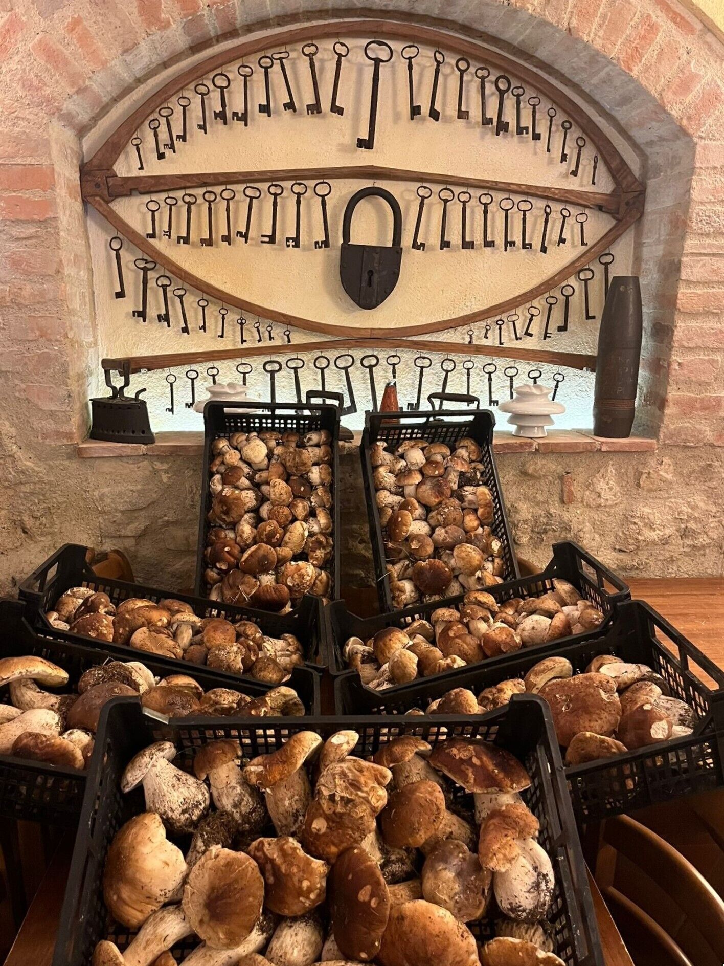 A display of mushrooms in crates with a wall-mounted key rack above.