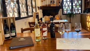 Una mesa de comedor con botellas de vino, copas, un menú y una caja de madera.
