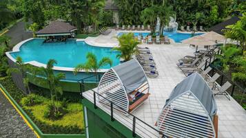 A rooftop pool area with lounge chairs and a small building.