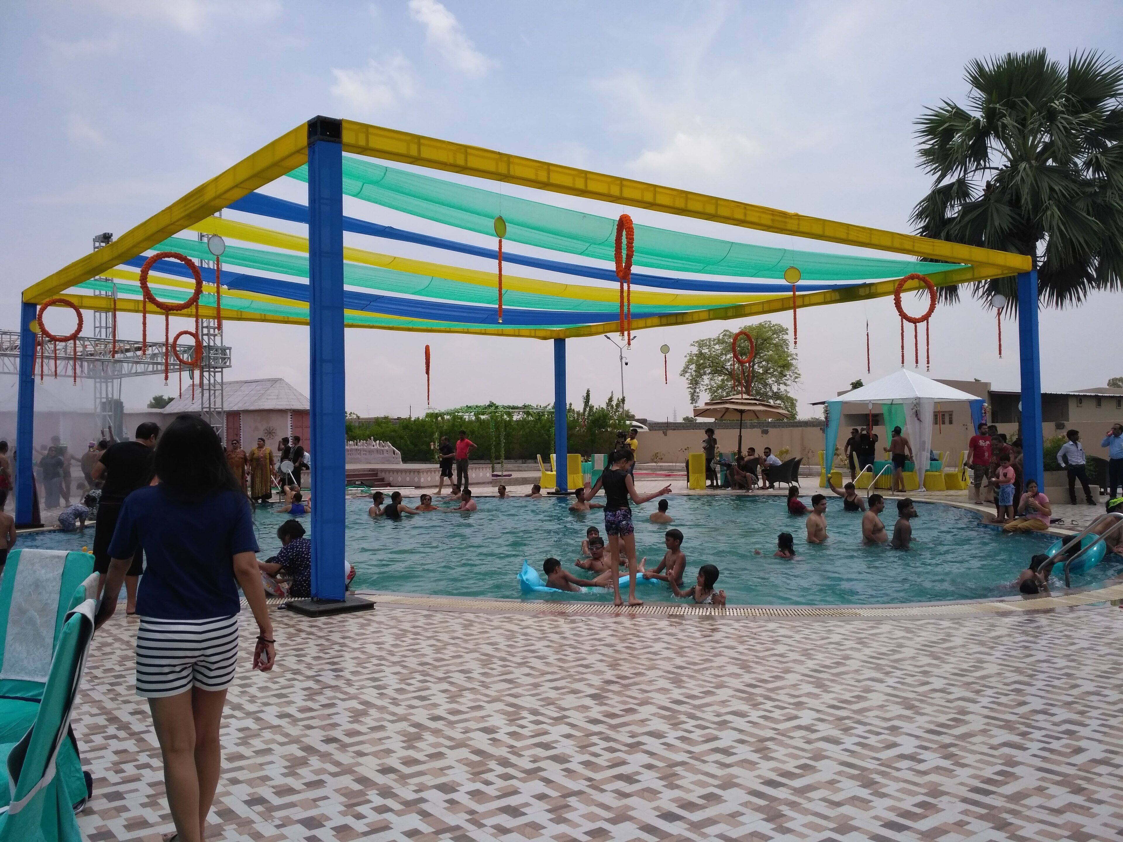 A swimming pool area with a covered section and a tiled deck.