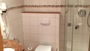 A bathroom with a toilet, sink, and shower.