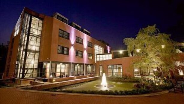 A multi-story hotel with a central courtyard and a fountain. - Hotel Mijdrecht Marickenland (Mijdrecht)