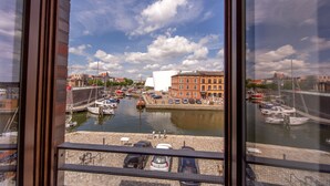 A view of a harbor with boats docked, a white building, and a clear sky. - Hotel Kontorhaus Stralsund (Stralsund)