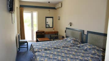 A hotel room with two beds, a desk, a chair, a mirror, and a television.