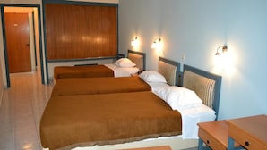 A hotel room with two beds, a wooden headboard, and wall-mounted lights.