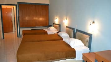 Ein Hotelzimmer mit zwei Betten, einem Holz-Kopfteil und Wandleuchten.