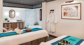 A modern hotel room with a large bed, a separate sitting area, a bathroom with a bathtub, and a framed painting on the wall. - Anantara Hoi An Resort (Da Nang)