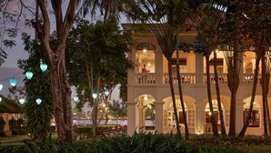 A multi-story building with balconies, arched doorways, and string lights.