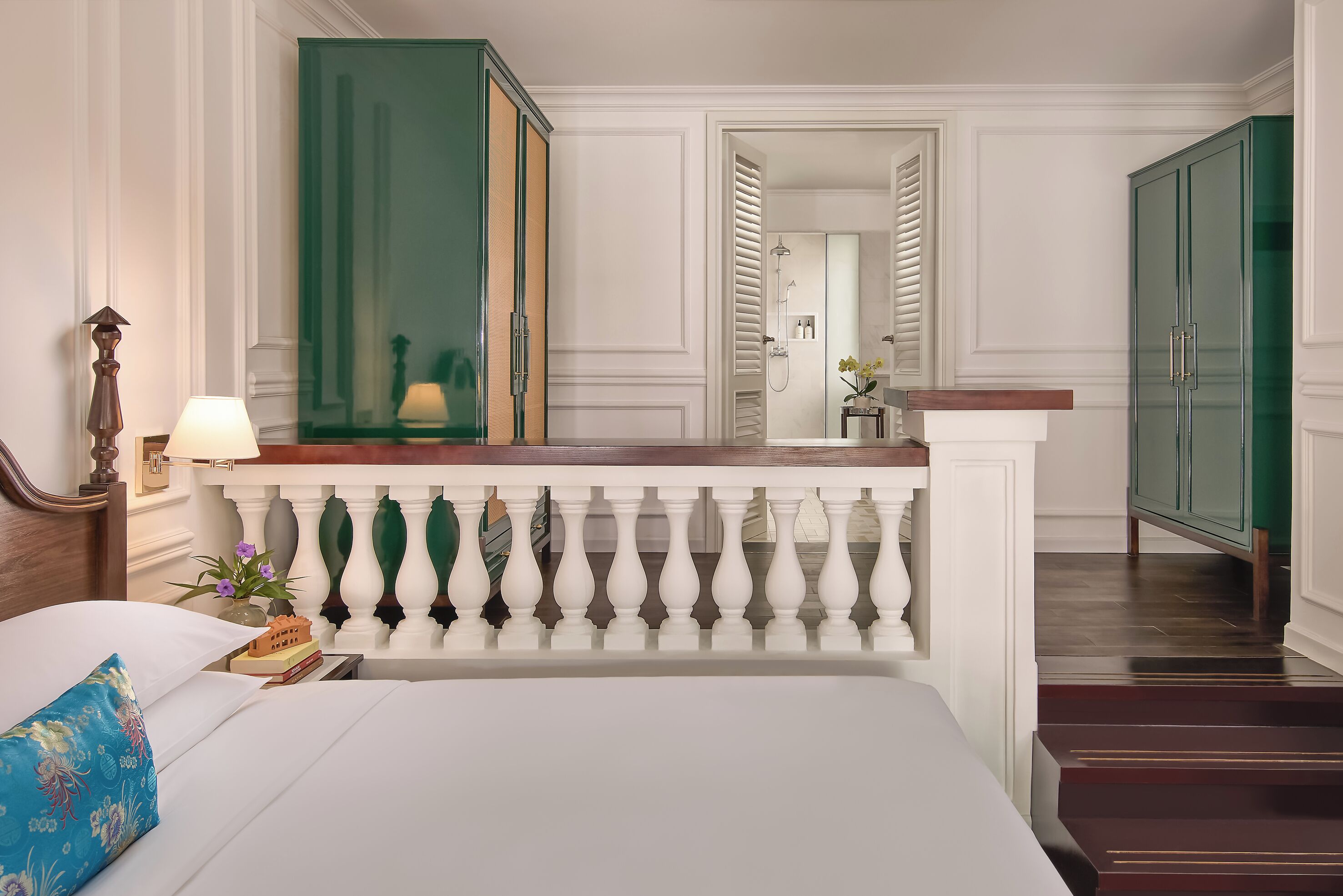 A hotel room with a bed, a nightstand, a lamp, a dresser, and a mirror.