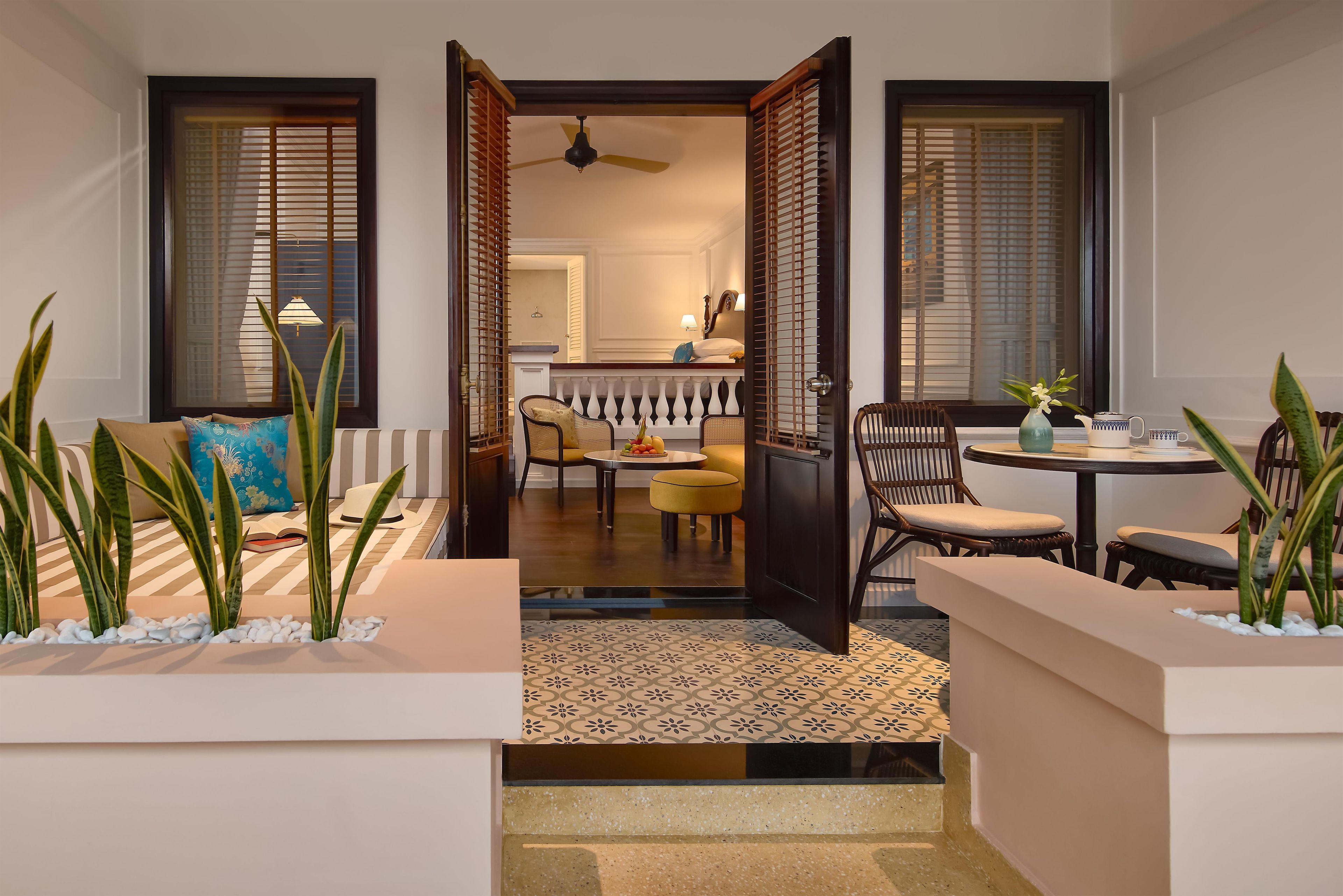 Ein Hotelzimmer mit Balkon, Essbereich und Blick ins Innere.