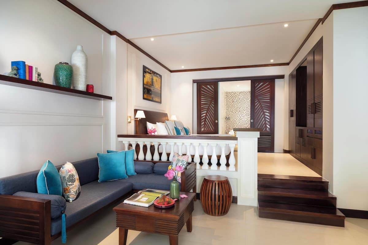 A living room with a sofa, coffee table, and decorative items. There is a staircase leading to another area.