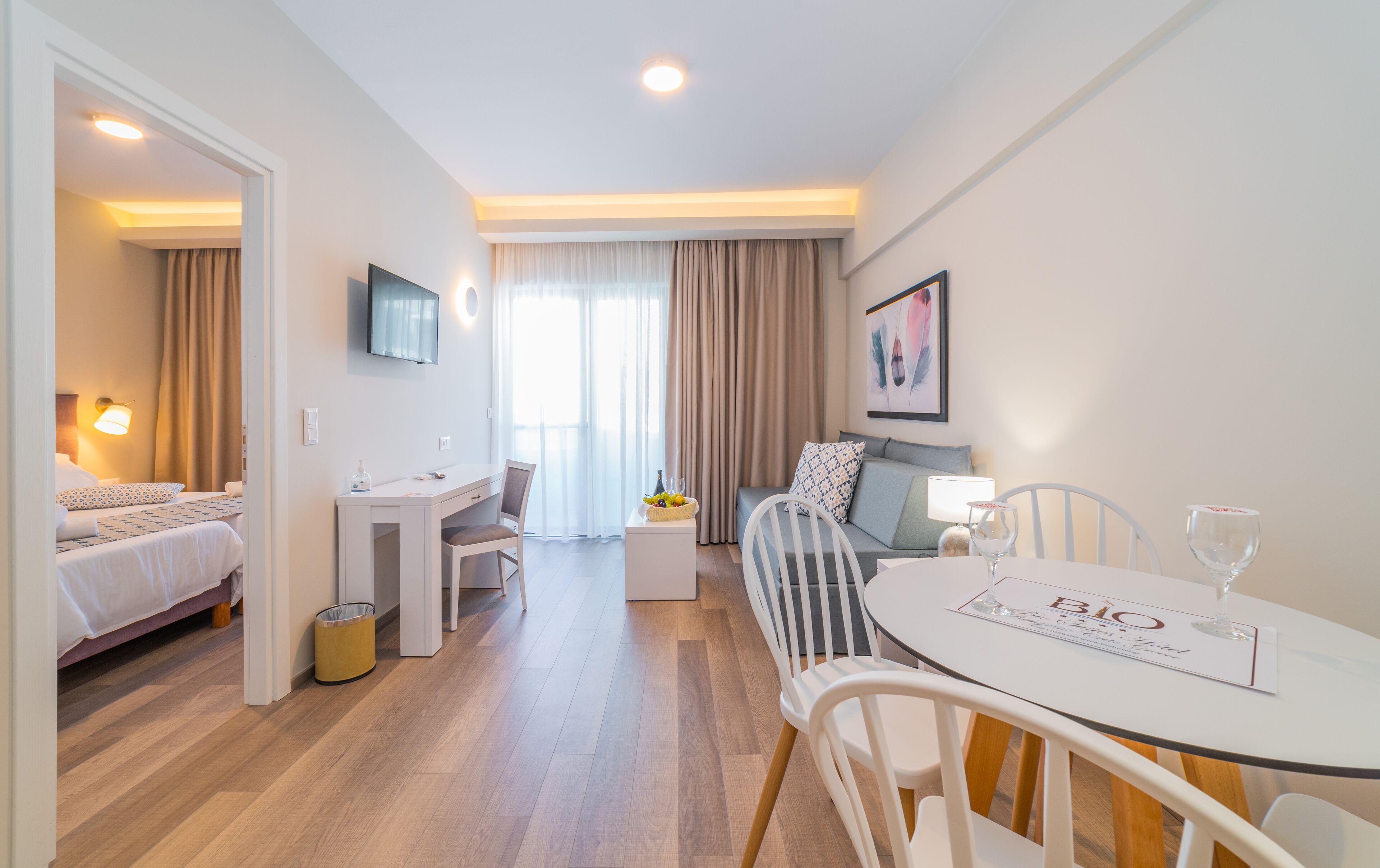 Una habitación de hotel moderna con cama, escritorio, mesa de comedor y televisión.