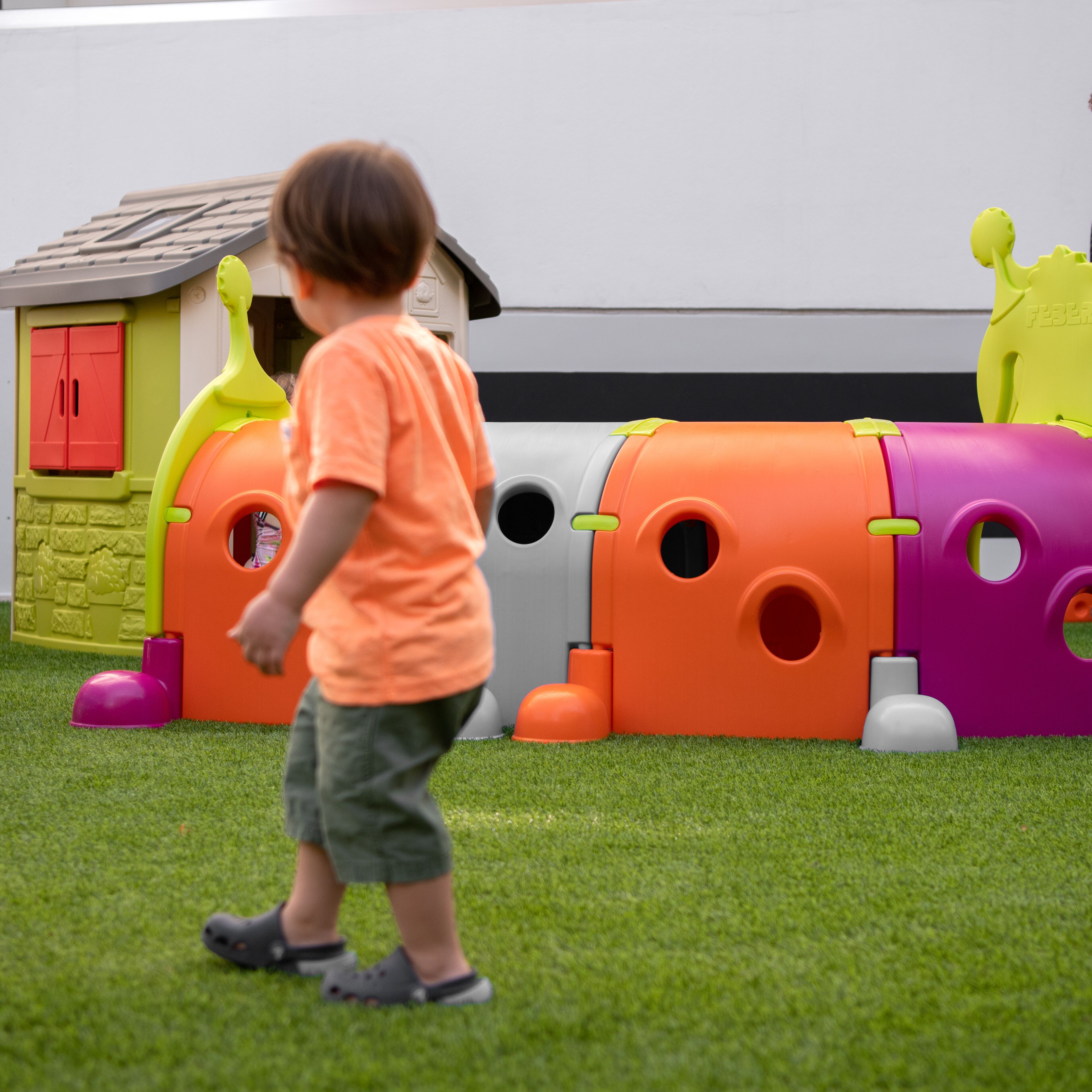 Un niño jugando en un área de juegos con estructuras coloridas.