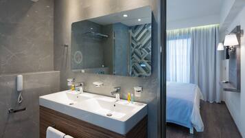 Un baño moderno con un espejo grande, lavamanos dobles y ducha.
