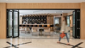 Un interior moderno con una zona de bar, asientos y un suelo pulido.