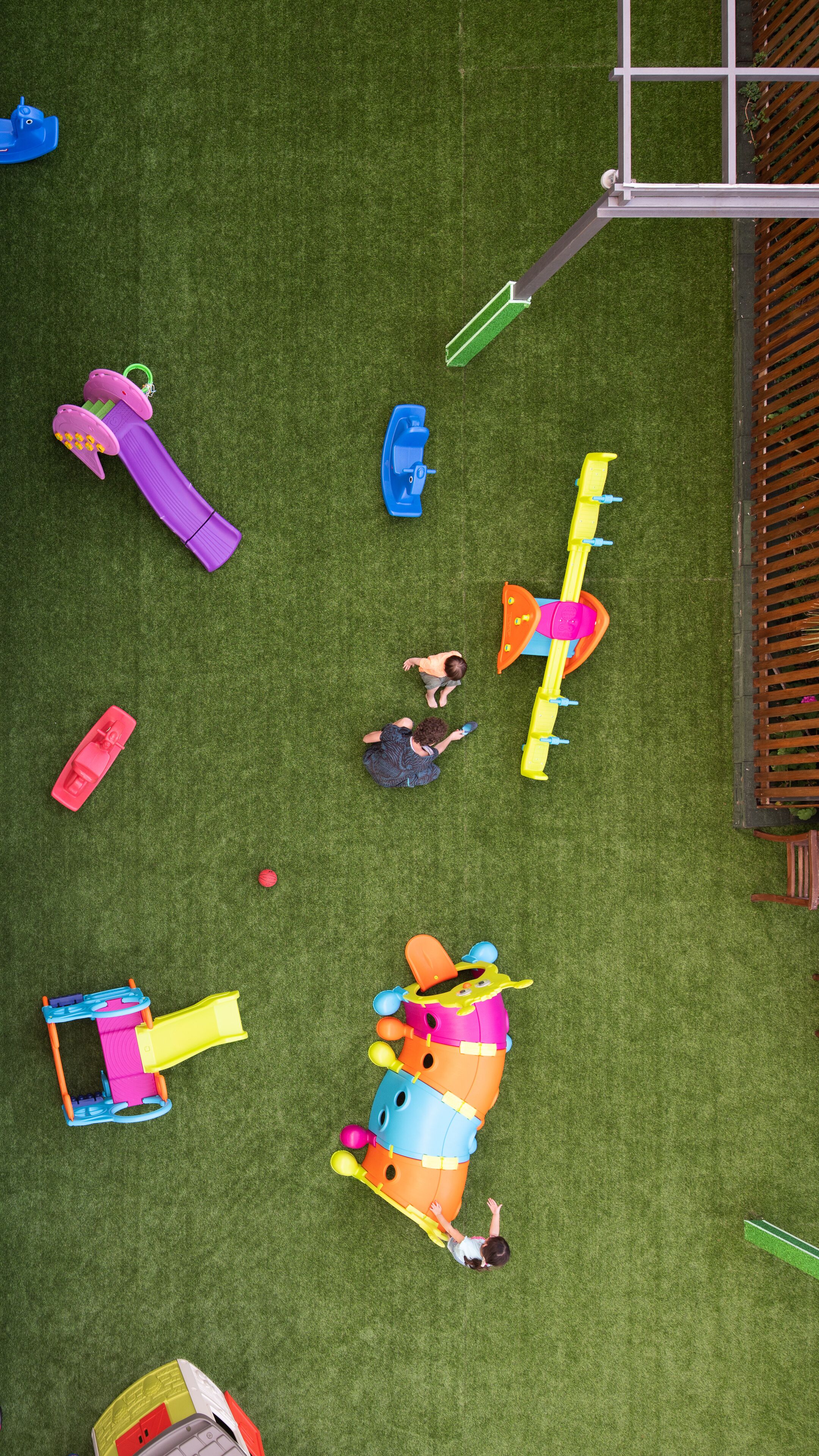 A playground with various play structures on artificial grass.