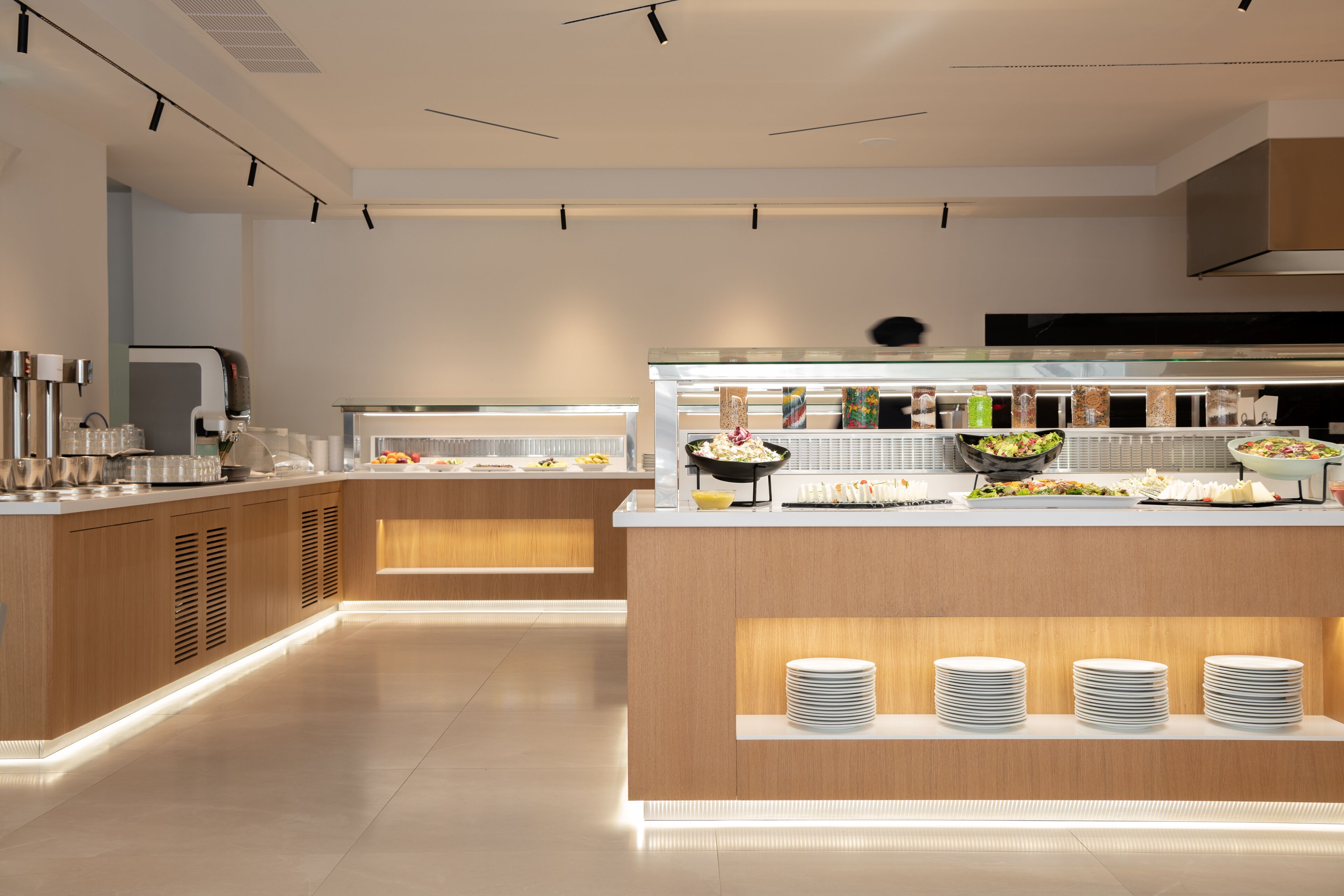 Un'elegante buffet con diverse postazioni gastronomiche, una macchina per il caffè e piatti disposti con cura.