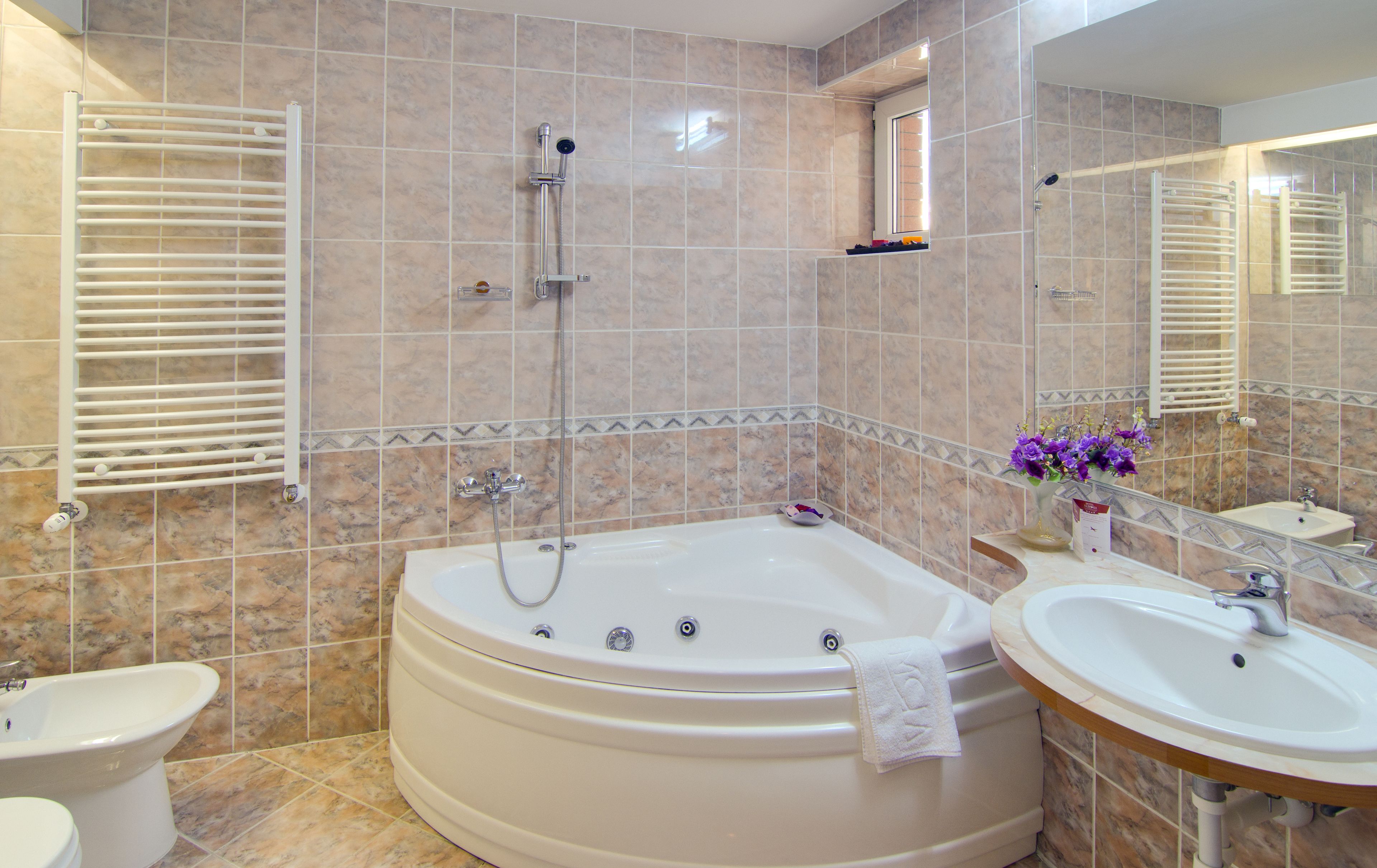 Ein Badezimmer mit einer großen Badewanne, zwei Waschbecken und einer Dusche.