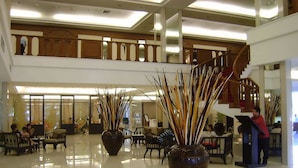 A spacious lobby with a high ceiling, a staircase, and seating areas. - Amora Hotel Tapae Chiang Mai (Chiang Mai)