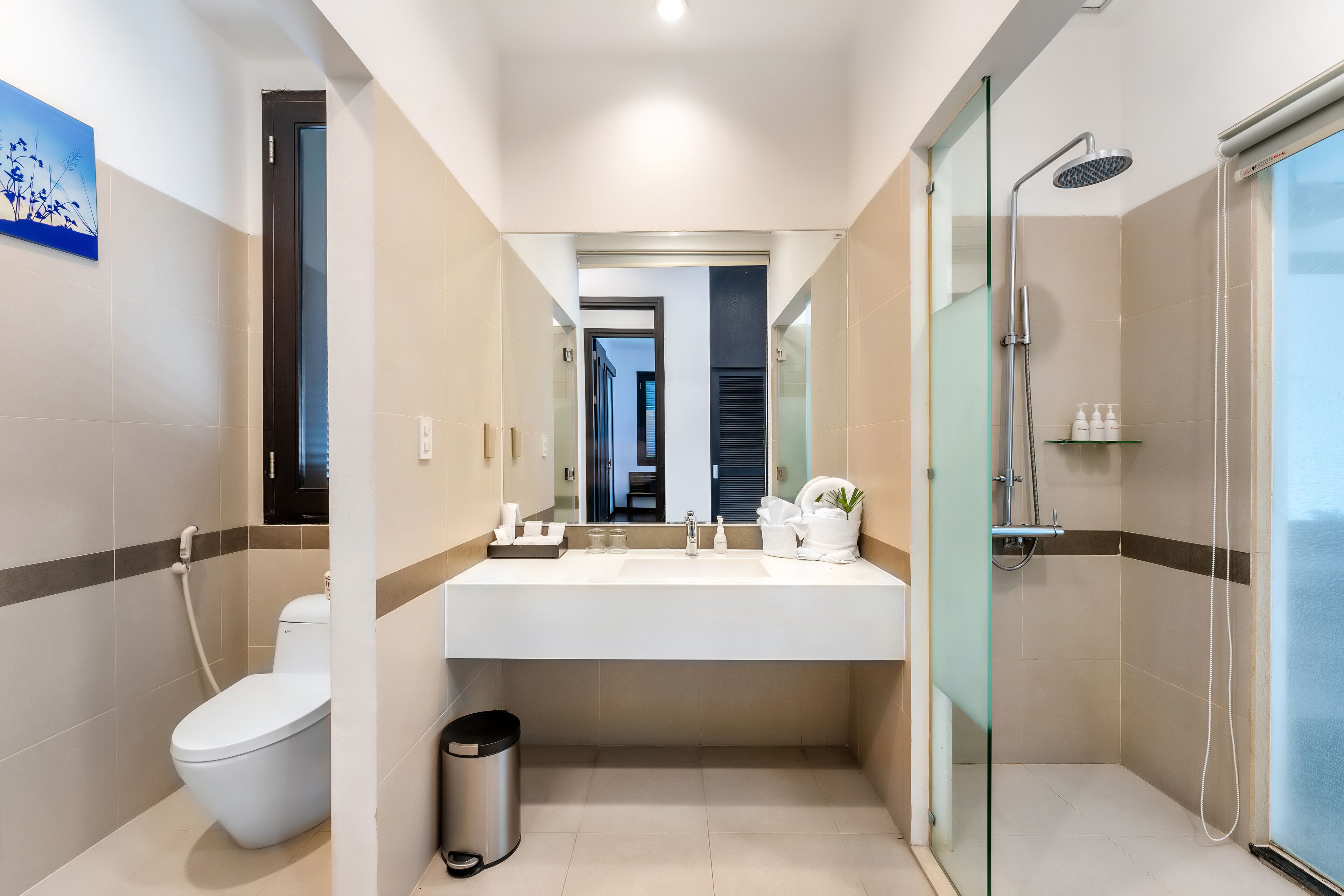Uma casa de banho moderna com sanita, lavatório e chuveiro.