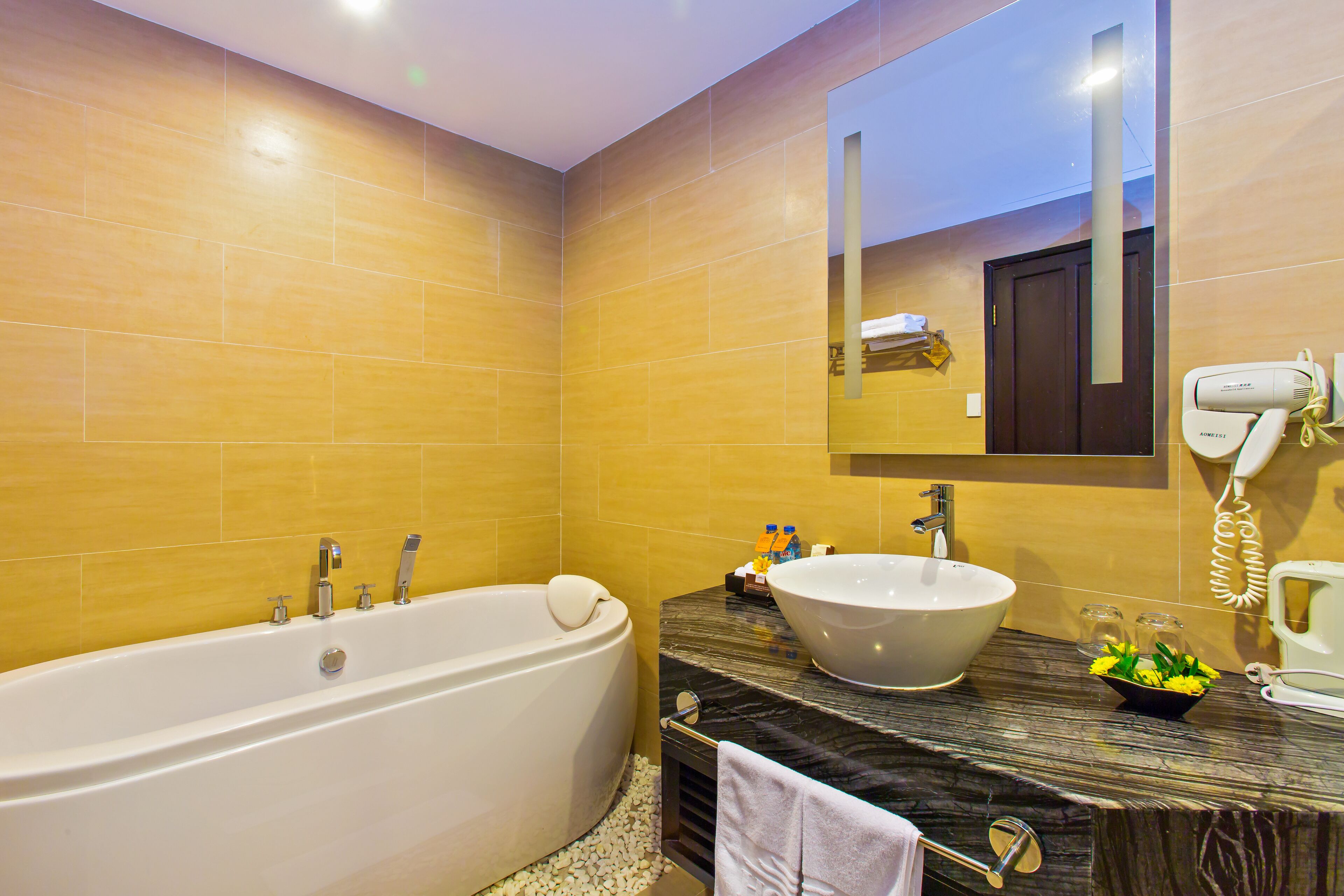 A modern bathroom with a freestanding bathtub, a vessel sink, and a marble countertop.