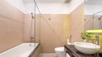 A modern bathroom with a bathtub, toilet, and sink.