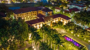 Un hotel grande de varios pisos con un patio interior y una piscina.